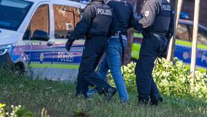 Zwei Polizisten bringen einen mutmaßlichen Hamas-Anhänger zu ihrem Polizeiauto.