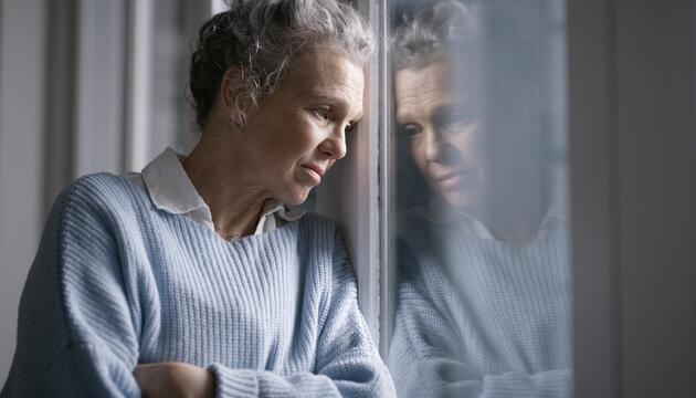ältere Frau blickt aus dem fenster