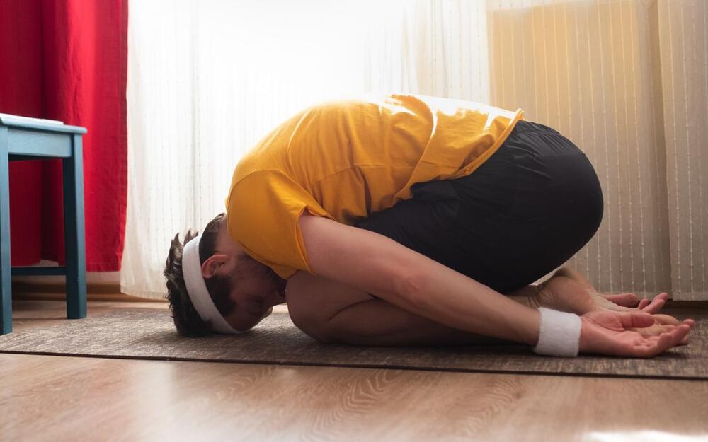 Yoga-Übung eines Mannes: Stellung des Kindes
