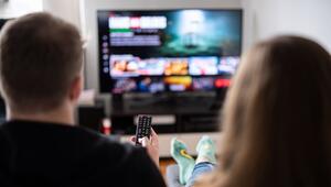 Paar sitzt vor einem Fernseher mit Streamingdiensten