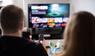 Paar sitzt vor einem Fernseher mit Streamingdiensten