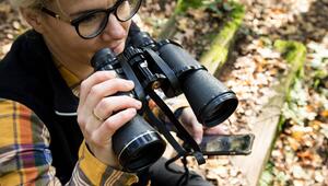 Eine Frau beobachtet die Tierwelt mit dem Fernglas
