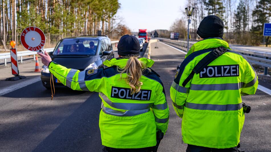 Eine Beamtin der Bundespolizei stoppt bei der Eireisekontrolle ein Auto