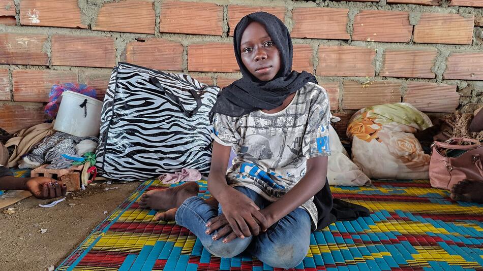 Ein junges Mädchen sitzt auf dem Boden