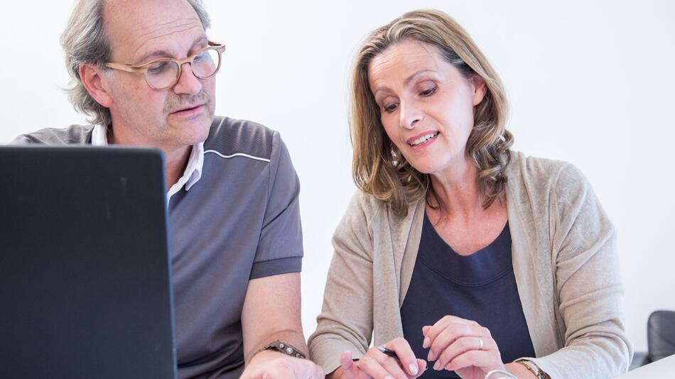 Zwei Menschen arbeiten am Laptop