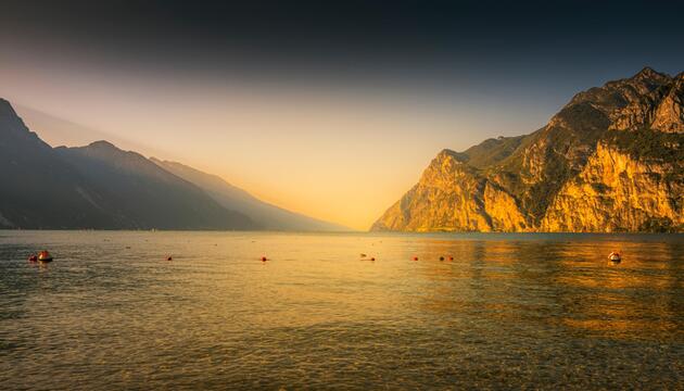 Familie sitzt am Pier in Malcesine und blickt auf den Gardasee.
