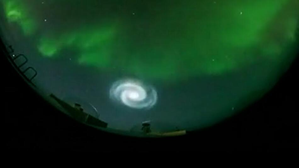 Polarlichter und leuchtende Spirale am Himmel über Alaska