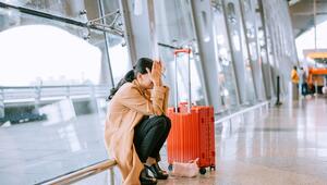 Eine Frau kniet verzweifelt am Flughafen