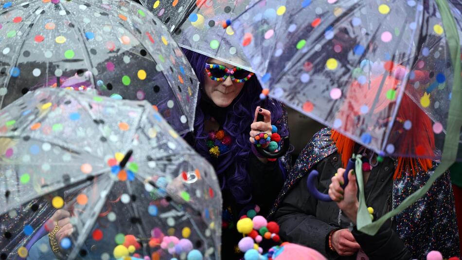 Verkleidete Jecken in Düsseldorf mit Regenschirmen