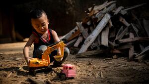 Ein kleiner Junge spielt auf dem Boden mit einem Bagger