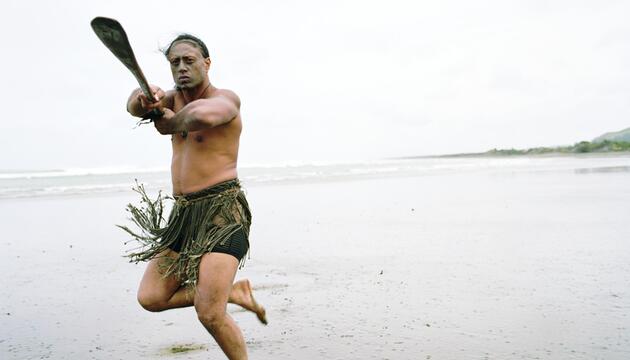 Maori-Mann performt Haka Powhiri am Strand