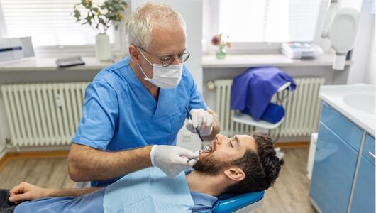 Ein Zahnarzt behandelt einen Patienten.
