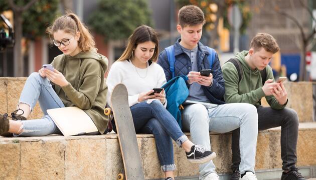 Jugendliche chatten auf ihrem Smartphon