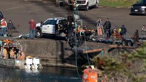 Ein Autowrack wird von einem Kran aus dem Fluss gehoben.