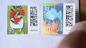 Person klebt Briefmarke auf Briefumschlag