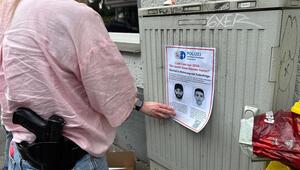 Polizeibeamte hängen Fahndungsplakat auf