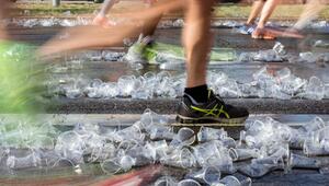 Ein Jogger läuft über benutzte Wasserbecher