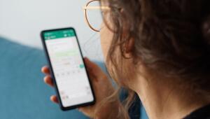 Eine junge Frau liest eine Nachricht auf einem Smartphone