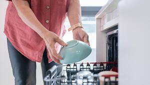 Frau räumt Schüssel in Spülmaschine