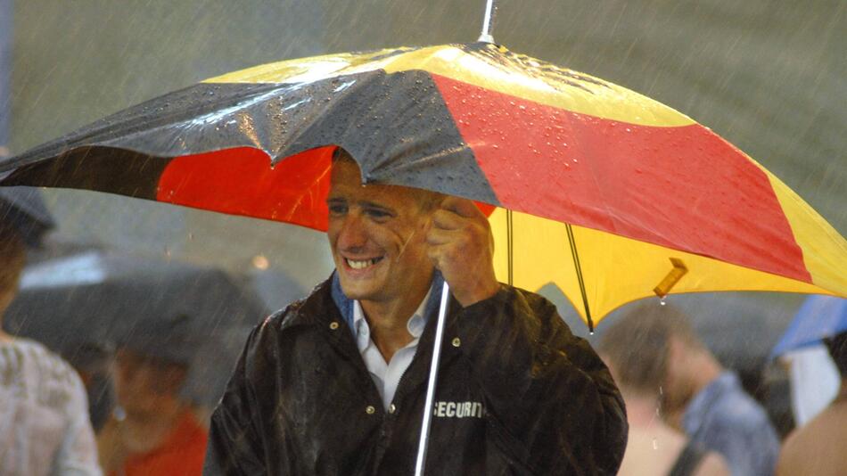 Mann unter Regenschirm