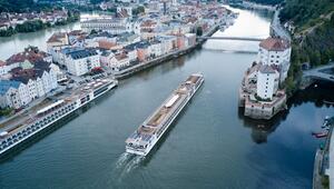 Ein Flusskreuzfahrtschiff fährt stromaufwärts an Passau vorbei