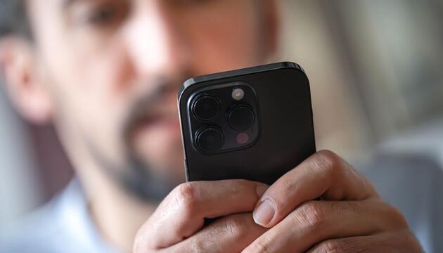 Ein Mann schaut auf ein Smartphone