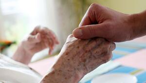 Eine Pflegerin hält die Hand einer Seniorin