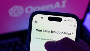 Smartphone mit dem KI-Chatbot ChatGPT vor dem Logo von OpenAI