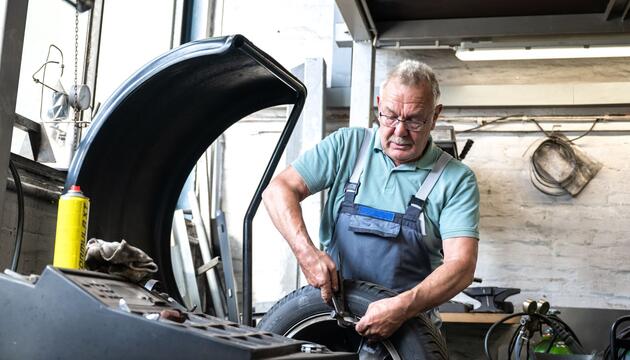 Ein älterer Mann arbeitet in einer Autowerkstatt