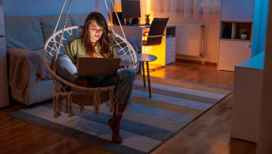 Frau sitzt nachts noch daheim am Laptop