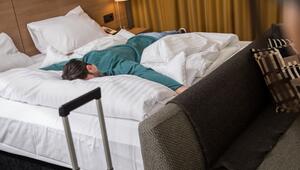 Ein Mann liegt erschöpft auf einem Bett in einem Hotelzimmer