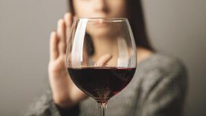 Frau lehnt ein Glas Rotwein ab