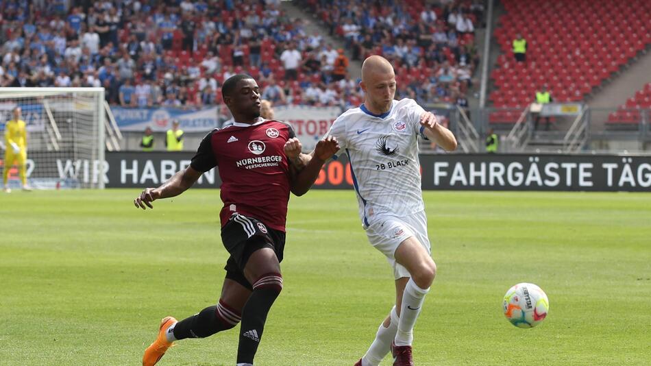 Kwadwo Duah vom 1. FC Nürnberg und Rick van Drongelen von Hansa Rostock kämpfen um den Ball.