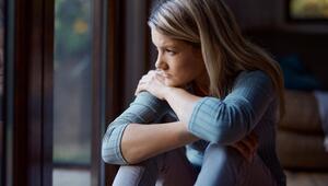 Junge Frau nachdenklich am Fenster