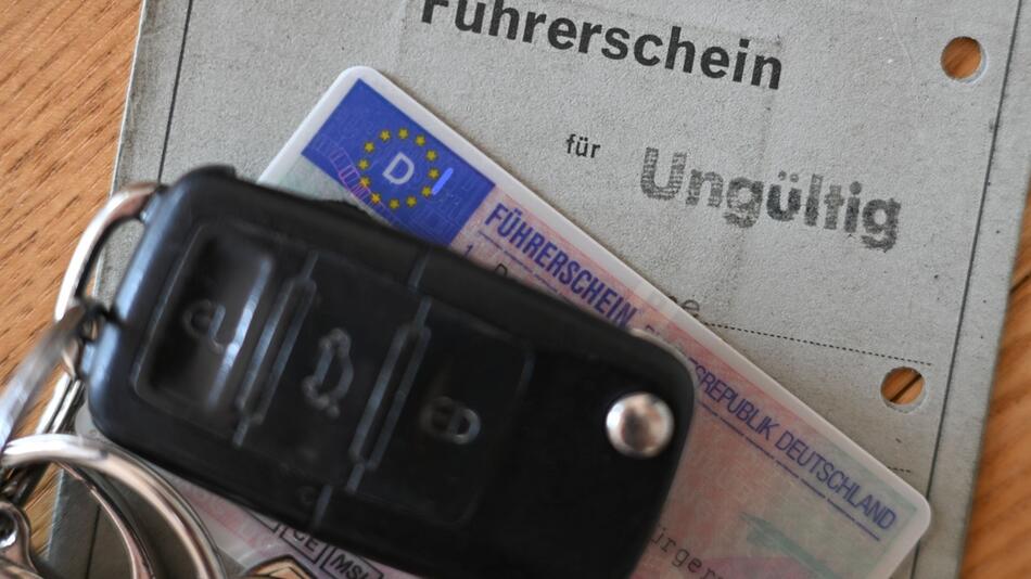 Ein Autoschlüssel liegt auf zwei Führerscheinen