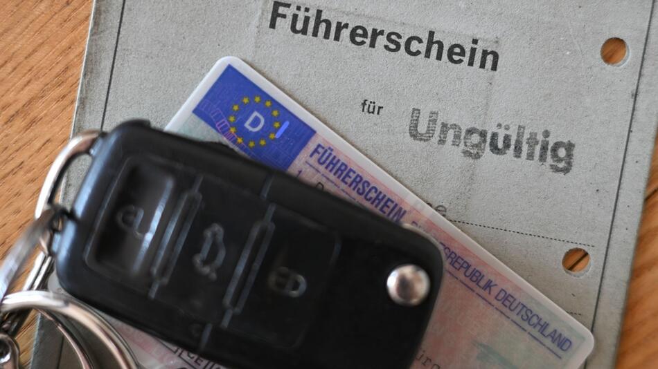 Ein Autoschlüssel liegt auf zwei Führerscheinen