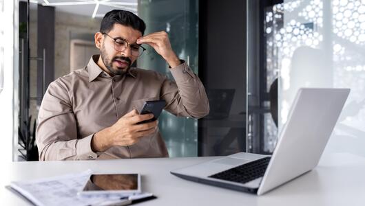 Mann regt sich auf, ist am Smartphone