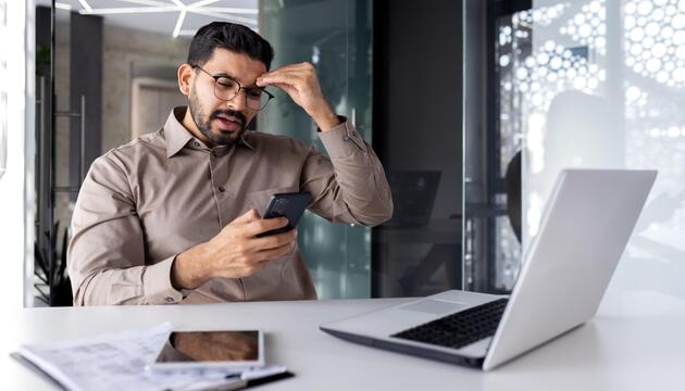 Mann regt sich auf, ist am Smartphone