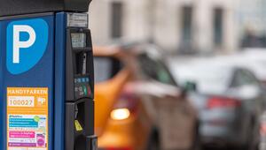 Parkscheinautomat steht vor parkenden Autos am Straßenrand