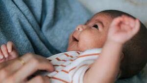 Mutter, die ein lachendes Baby auf dem Arm hält. 