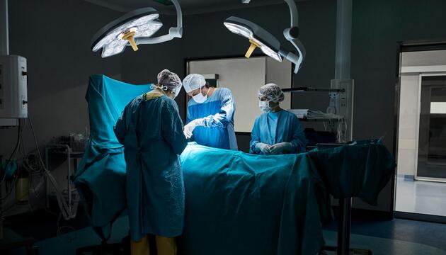 Symbolbild: Ärzte operieren einen Menschen in einem OP-Saal