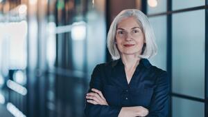 Porträt einer selbstbewussten Geschäftsfrau, die in modernen Büroräumen steht.