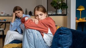 Frustriertes, beleidigtes Teenager-Mädchen sitzt neben der Mutter