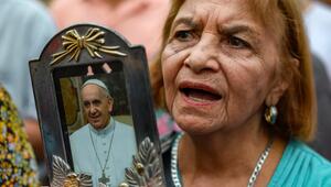 Frau betet mit Foto von Papst Franziskus in der Hand