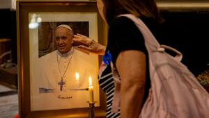 Eine Frau berührt ein Foto von Papst Franziskus.