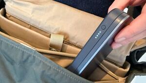 Mann steckt eine Powerbank in seinen Rucksack
