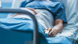 Patient in Krankenhausbett mit Pulsoximeter am Finger